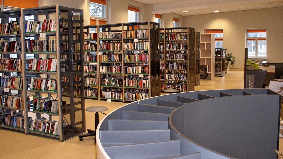 Meble na zamówienie dla biblioteki. Wyposażenie: sofa, regały biblioteczne, szafy, stolik, biurko, fotele, krzesła, lada biblioteczna, meble nietypowe